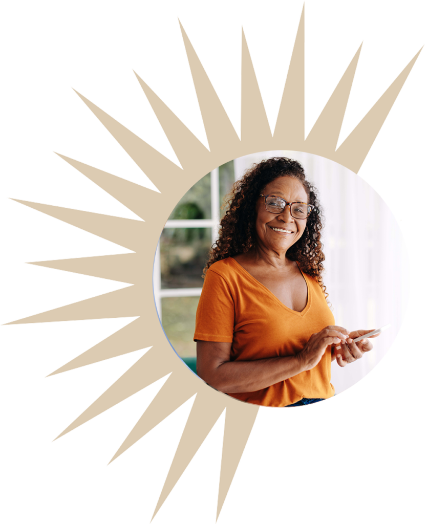 a senior smiles and uses a phone