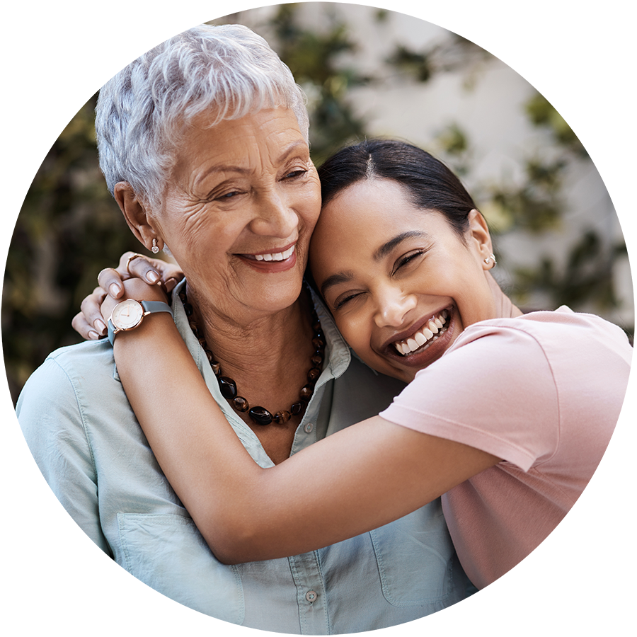 a senior and nurse embrace and smile