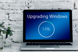 a computer reading "Upgrading Windows 14%"