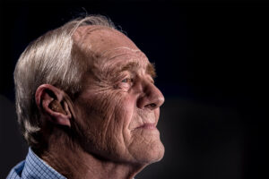 a senior looks ahead while wearing a hearing aid