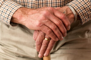 a senior's hands on a cane