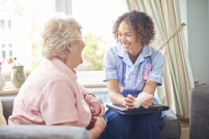 a home healthcare worker talks with a senior