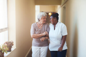 Nurse walks with senior as they discuss benefits of working in the home healthcare industry