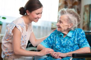 Senior looks at nurse during memory care services at home