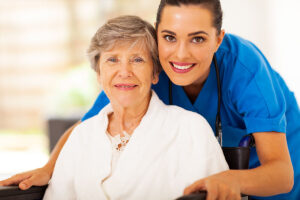 Nurse smiles and poses next to senior after starting work at an award winning healthcare company