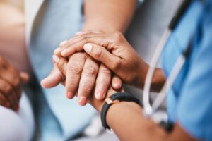 Nurse holds patient's hand as she embarks in a career in home healthcare