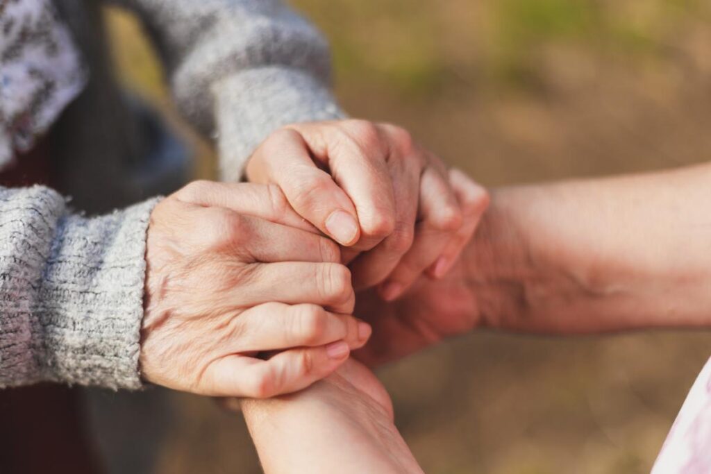 Nurse holds hands with a senior as they discover the benefits of respite care