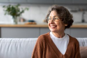 Woman sits on couch and wonders what is at home healthcare