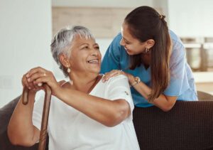 Woman chats with senior during home health maintenance therapy for chronic conditions