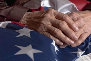 Seniors hands folded on an American flag