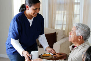 Woman gives food to senior during aging in place care