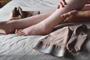Woman rubs her ankles after discovering how to manager her lymphedema at home